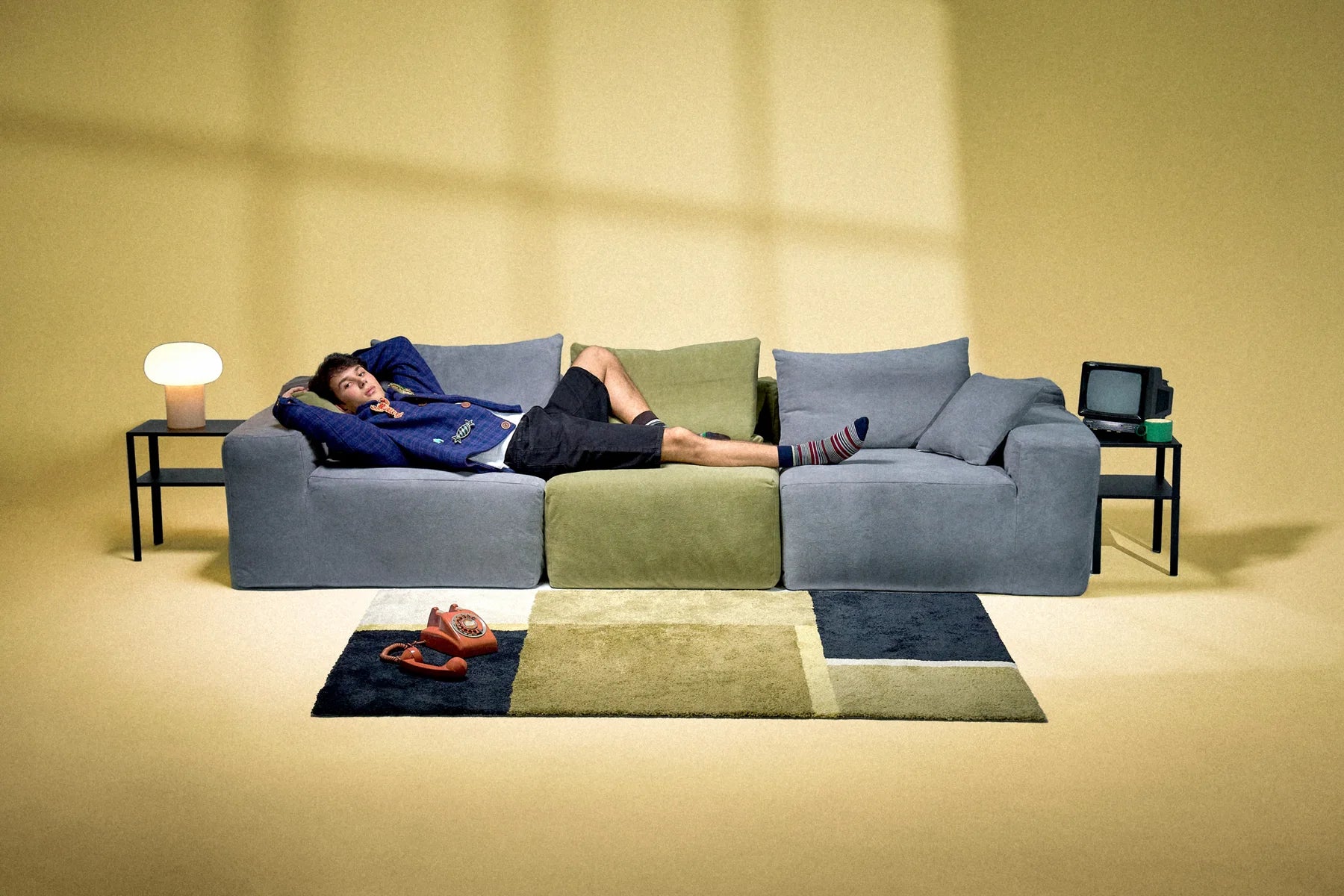 Person lounging on a three-color Modu cube sofa